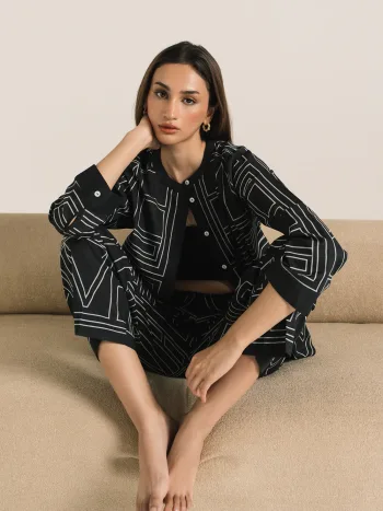 Women's jet black two-piece coord set with white geometric print, button-down ban neck top, and straight-fit trousers